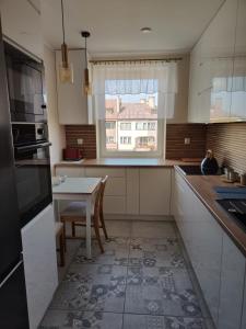 a kitchen with a table and a window at Villa Leofal in Suwałki