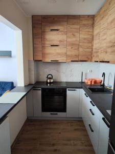a kitchen with white cabinets and a black dishwasher at Villa Leofal in Suwałki +18 photos