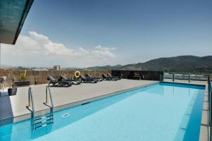 une piscine avec des chaises longues sur le toit dans l'établissement Sercotel Ciutat de Montcada, à Montcada i Reixac