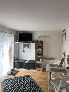 a living room with a tv and a desk with a chair at Chez Titian Vue sur le Mont St Michel in Pontaubault