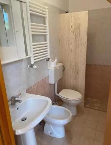 uma casa de banho com um lavatório branco e um WC. em Villa Adelaide em Ceglie Messapica
