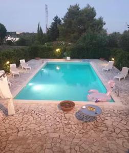 a swimming pool with a pink swan and chairs and a toy at Villa Adelaide in Ceglie Messapica