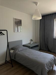 a bedroom with a bed and a table and a lamp at Tallinn Street Apartment in Kuressaare