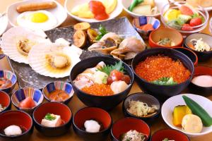 a table topped with bowls of food and plates of food at Dormy Inn PREMIUM Kushiro in Kushiro