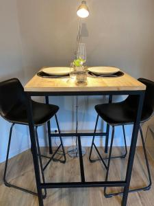 une table en bois avec des chaises noires et une lampe dans l'établissement Les terrasses de Port Nabat 2, à Vannes