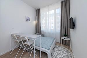 a small white room with a table and chairs at UAB Laisvės alėjos viešbutis in Kaunas