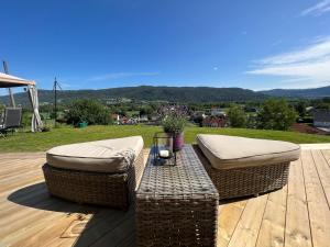 two wicker chairs and a table on a wooden deck at Valley House in Notodden