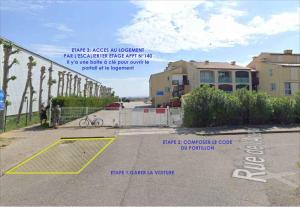 een uitzicht op een parkeerplaats met een poort en een gebouw bij Studio Gruissan in Gruissan