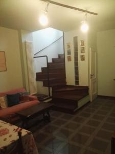 sala de estar con escalera y sofá en La casetta rosa, en Fano