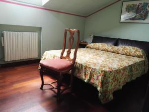 a bedroom with a bed with a chair and a couch at La casetta rosa in Fano