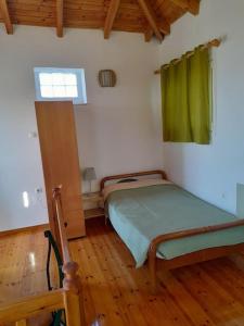 um pequeno quarto com uma cama e uma janela em Frantato Seaview em Akamatra