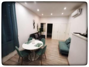 a living room with a table and green chairs at Roquebrune : Appartement 4 personnes proche de la plage (AV) in Roquebrune-Cap-Martin