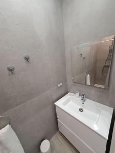 a white bathroom with a sink and a mirror at Roquebrune : Appartement 4 personnes proche de la plage (AV) in Roquebrune-Cap-Martin