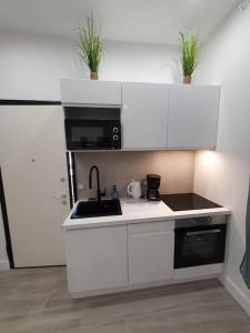 a white kitchen with a sink and a microwave at Roquebrune : Appartement 4 personnes proche de la plage (AV) in Roquebrune-Cap-Martin