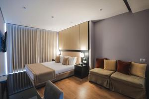 Habitación de hotel con cama y sofá en Hotel Oasis en Sarandë