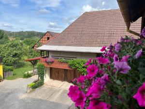 une maison avec des fleurs roses devant elle dans l'établissement Ferienzimmer Reurieth, 