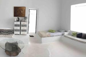um quarto branco com 2 camas e uma mesa de vidro em Studio III at orig. Finca,, sea views em La Asomada