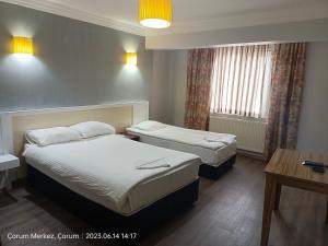 a hotel room with two beds and a table at Şirin Apart in Corum