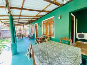 a green room with a table and chairs at Rock Lake Home Stay in Sigiriya