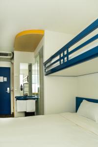 ein Schlafzimmer mit einem Bett und ein Badezimmer mit einem Waschbecken in der Unterkunft Ibis Budget Graz City in Graz