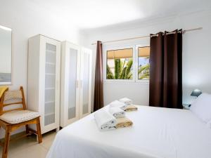 ein Schlafzimmer mit einem Bett, einem Stuhl und einem Fenster in der Unterkunft Casa Peter Los Cristianos in Los Cristianos