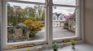 an open window with a view of a house at Bibby Lot in Rusland