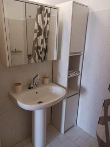 a bathroom with a sink and a mirror at Reggina's place in Kefallonia