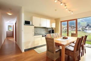a kitchen and dining room with a wooden table and chairs at Reiterhof in Westendorf