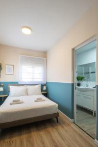 a bedroom with a large bed and a bathroom at Domus Bat Galim Hotel in Haifa