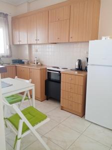 a kitchen with wooden cabinets and a white refrigerator at Alasrooms Γ1 in Missolonghi