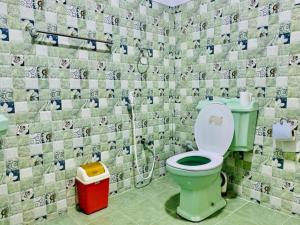 bagno con servizi igienici verdi e parete piastrellata di Rock Lake Home Stay a Sigiriya