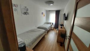 a room with two beds and a television in it at APARTMAN Zengg in Senj