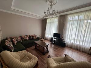 sala de estar con sofá y 2 sillas en Mountain KAZBEGI Apartment, en Kazbegi