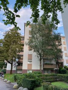 um prédio de apartamentos com árvores em frente em Alloggio Dolomites em Bolzano