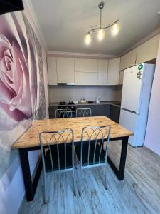 a kitchen with a wooden table and two chairs at Mountain KAZBEGI Apartment in Stepantsminda