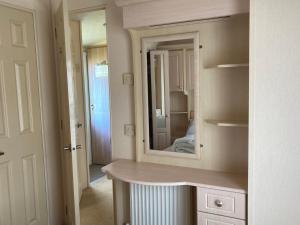 een badkamer met een spiegel en een kaptafel bij Luxury 8 and 6 berth caravans in Jaywick Sands