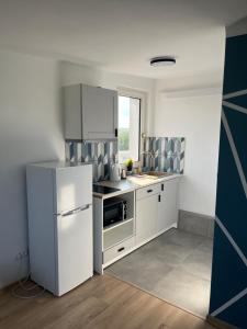 a kitchen with a white refrigerator and a sink at Murano Apartaments City Center Duo in Warsaw