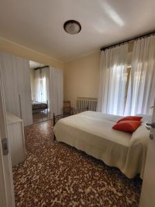 sypialnia z łóżkiem z czerwonymi poduszkami w obiekcie Casa Margherita - bike friendly w mieście Verbania