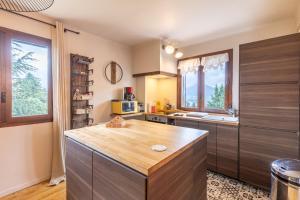 una cocina con una isla de madera en una habitación en La Rose de Lou - Grand duplex avec vue montagne, en Bolquere Pyrenees 2000