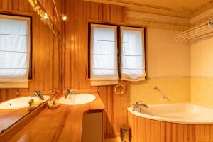 ein Badezimmer mit 2 Waschbecken und einer Badewanne in der Unterkunft La Rose de Lou - Grand duplex avec vue montagne in Bolquere