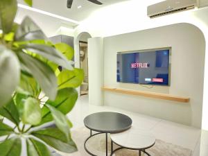 a waiting room with a table and a tv at Country Garden Danga Bay InStyle Sea View Homestay Suite by NEO in Johor Bahru