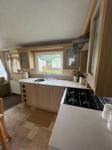 a kitchen with a sink and a stove top oven at Bryn Morfa Holiday Park Conwy North Wales in Conwy