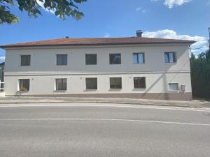 un edificio blanco al lado de una calle en Villa Acernis, en Postojna