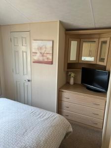 a bedroom with a bed and a flat screen tv at Bryn Morfa Holiday Park Conwy North Wales in Conwy