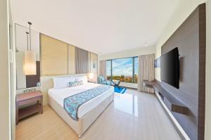 Habitación de hotel con cama y TV de pantalla plana. en The Resort en Bombay