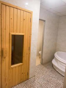 een badkamer met een toilet naast een deur bij Hung Vuong Hotel in Pleiku