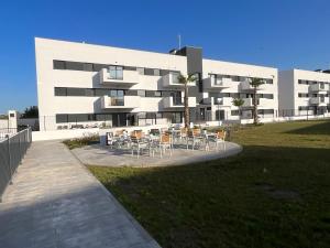 un edificio con mesas y sillas delante de él en Sueño Playa en Benajarafe