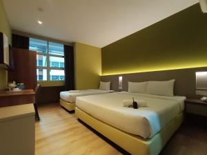 a hotel room with two beds and a window at Yee Hotel Permas in Johor Bahru
