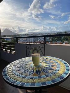 un tavolo di vetro con una tazza sopra un balcone di Spacious beach property in Flic en Flac a Flic-en-Flac