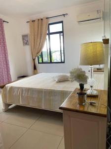 una camera da letto con un letto grande e una finestra di Spacious beach property in Flic en Flac a Flic-en-Flac